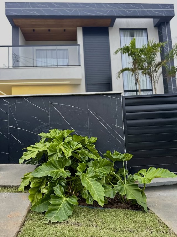 Fachada residencial com jardim tropical
